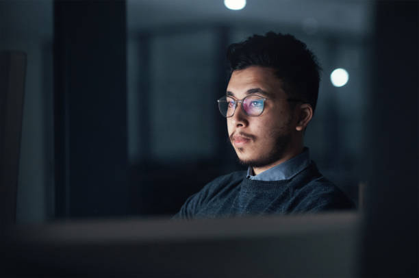 istock Shot of a young businessman using a computer during a late night in a modern office 1316372366