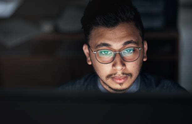 istock Shot of a young businessman using a computer during a late night in a modern office 1316372368