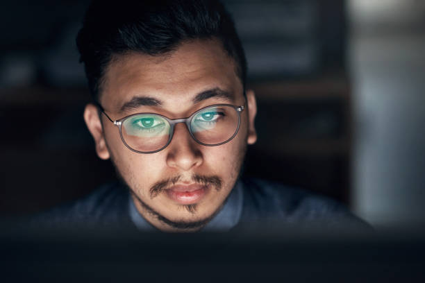 istock Shot of a young businessman using a computer during a late night in a modern office 1316372369