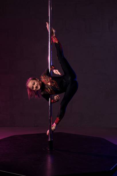 istock Graceful girl doing gymnastic exercise near pole in darkness 1316372490
