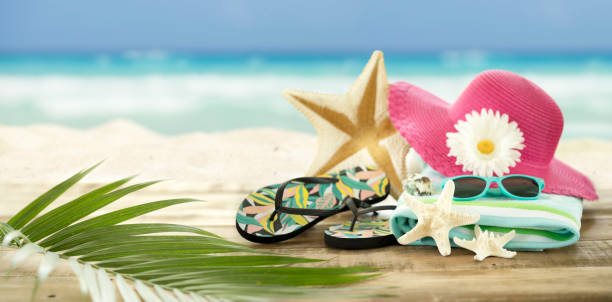 istock Sunhat, flip-flops and seashells against an ocean beach background 1316372498