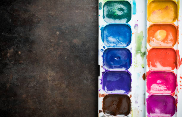 istock White plastic container with artistic brush and watercolor paints. Shot from above. 1316375700