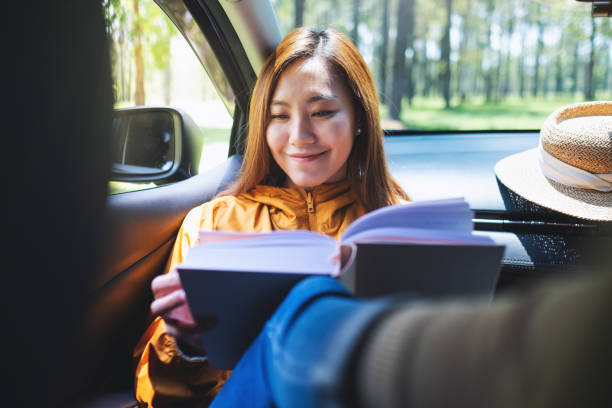 istock A young asian woman reading book while riding the car 1316381977