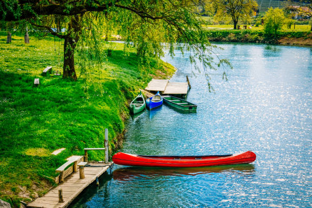 istock Canoes and boat at riverbank 1316382735
