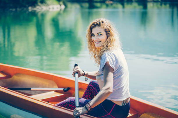 Happy beautiful woman canoeing at river Krka, at Kostanjevica pri Krki, Slovenia.