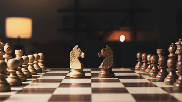 istock Chess pieces arranged on the chessboard and knights facing each other 1316383072