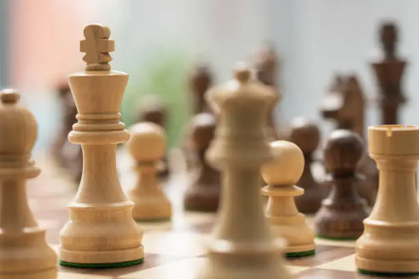 Chess game: pieces on the chessboard and king close up