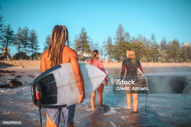 Burleigh Heads Surfers Walking In Shallow Water With Boards Stock Photo - Download Image Now