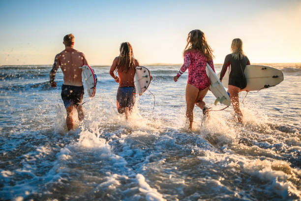 istock Surfers with Boards Running into Water at Burleigh Heads 1316390069