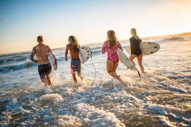istock Surfers with Boards Running into Water at Burleigh Heads 1316390075