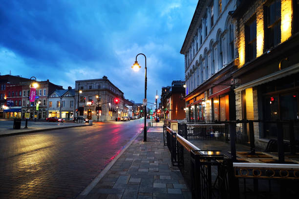 Downtown Kingston at Night, Brock St Market Square Downtown Kingston, Ontario Canada shortly after dusk with reflections and brilliant blue cloudy sky. Downtown Kingston Stock Photo. Springer Market Square and Patios with Modern Street Lamp. kingston ontario photos stock pictures, royalty-free photos & images