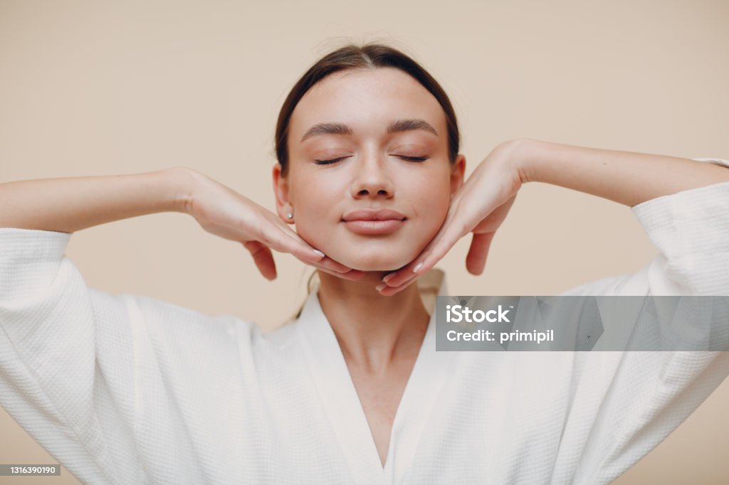 Young woman doing face building facial gymnastics self massage and rejuvenating exercises Young woman doing face building facial gymnastics self massage Facial Mask - Beauty Product Stock Photo