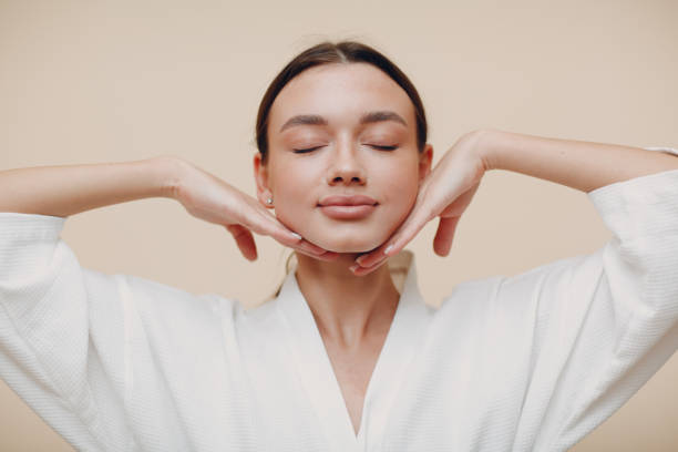 Young woman doing face building facial gymnastics self massage and rejuvenating exercises stock photo