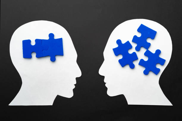 istock Papercut head with jigsaw puzzle pieces on black background 1316391327