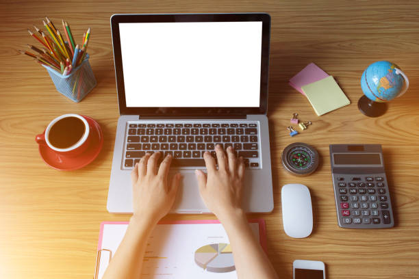 istock Top view female hands working on modern laptop. Office desktop on wooden background 1316392265