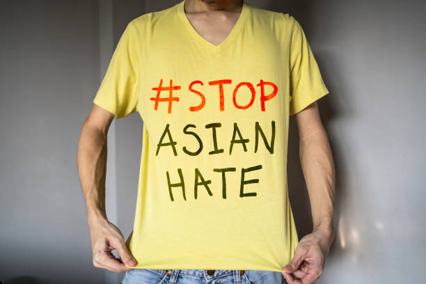 мужчина в желтой футболке с текстом stop asian hate - protestor protest sign yellow стоковые фото и изображения