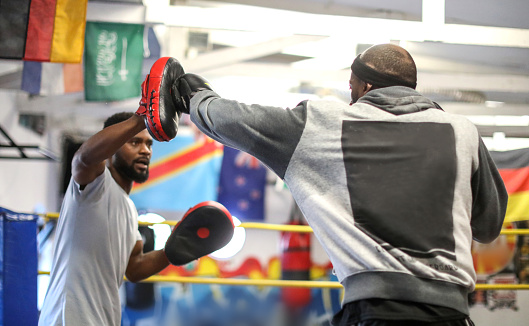 Boxing hook punch. Closeup two professional boxer in sports uniform training together isolated on white studio background. Concept of sport, competition, training, energy. Copy space for ad, text