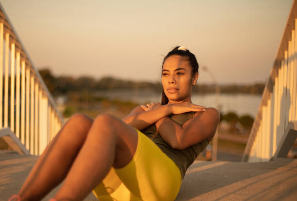 istock Young female athlete performs abs crunches outdoors. 1316395223