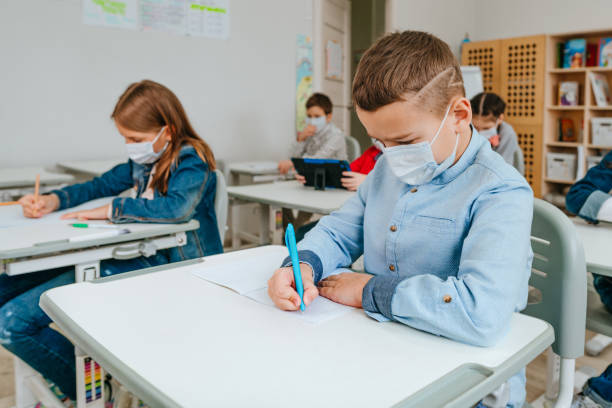 istock Elementary school students studying in the classroom during COVID-19 pandemic. 1316395324