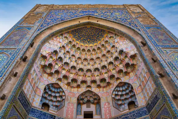 Abdulaziz Khan Madrasa Iwan - Muqarnas Entrance Gate Islamic Architecture Detail from the year 1652 in the city of Bukhara opposite of the famous Ulugbek Medressa. Colorful Mosaic and Tiles aroung the Iwan into the Abdulaziz-Khan Medressa. Abdulaziz Khan Madrasa, Bukhara - Buxoro - Бухорo, Silk Road, Uzbekistan, Central Asia