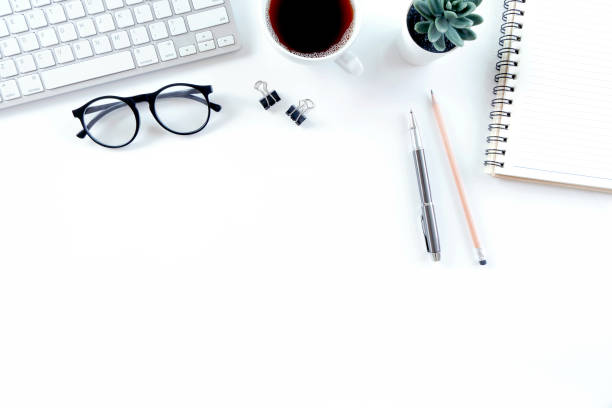 istock Modern white office desk table with keyboard computer, notebook, tree, glasses and cup of coffee. Top view with copy space, 1316397857