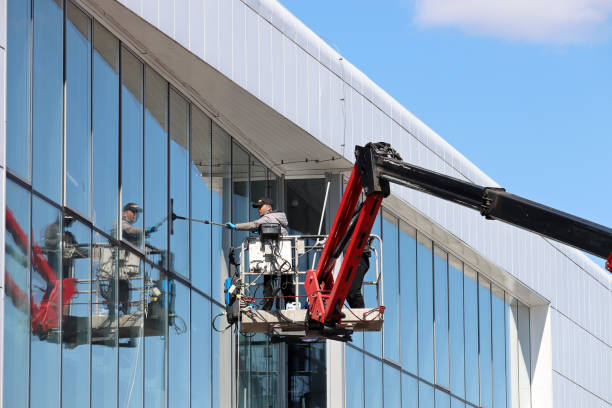 Worker washes the window standing on lifting platform Moscow, Russia - May 2021: Worker washes the window on the high rise building facade on Moscow street steeplejack stock pictures, royalty-free photos & images