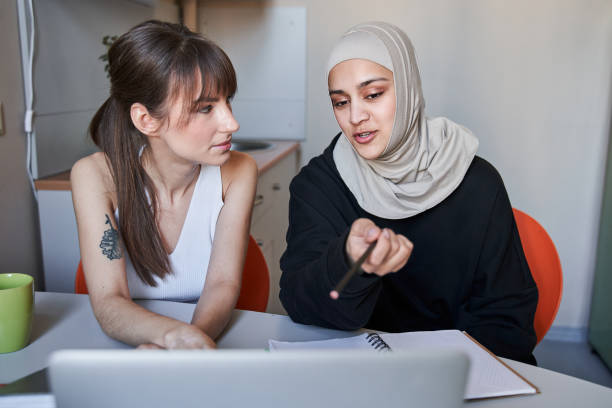 istock Woman wearing hijab pointing with her finger to the laptop screen while explaining something 1316401929
