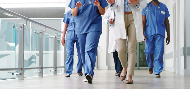 Imagen recortada de un grupo diverso de médicos que caminaban por el pasillo del hospital photo