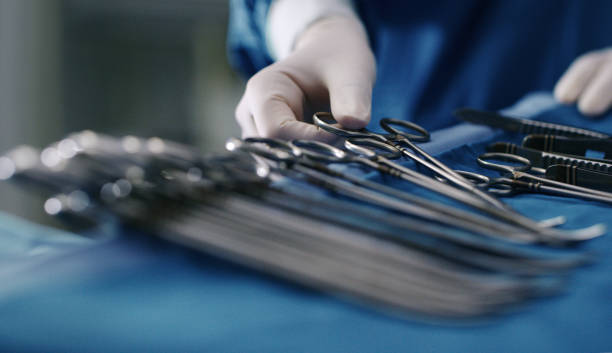 Cropped shot of an unrecognizable doctor removing a pair of forceps from a tray of surgical instruments Preparing for surgery is key to a successful operation forceps stock pictures, royalty-free photos & images