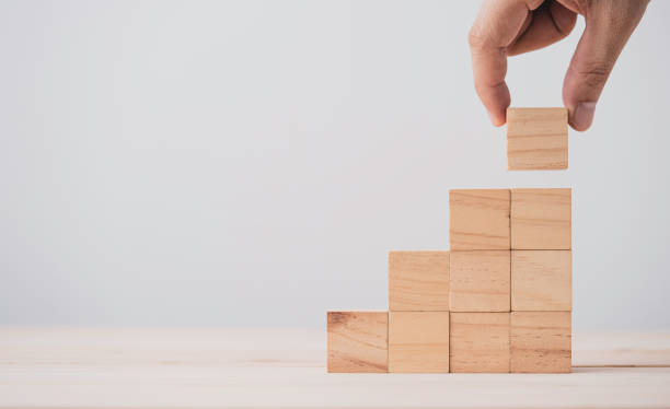 istock Hand putting and stacking blank wooden cubes on table with copy space for input wording and infographic icon. 1316403875