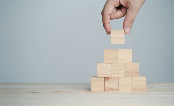istock Hand putting and stacking blank wooden cubes on table with copy space for input wording and infographic icon. 1316403930
