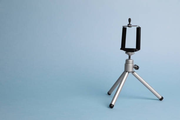 istock Modern stylish mobile tripod on light blue background. Space for text 1316405462