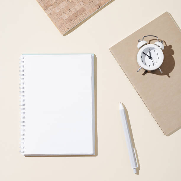 istock Autumn working  space with open notebook with blank pages and white clock show day time. Autumnal time and mood concept. 1316411248