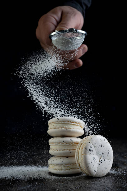 istock Cook sprinkles macaroon on black background. Close up. 1316411542
