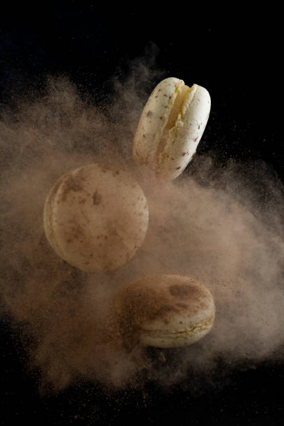 istock flying macaroons on a black background, freezing in motion with cocoa. 1316411567