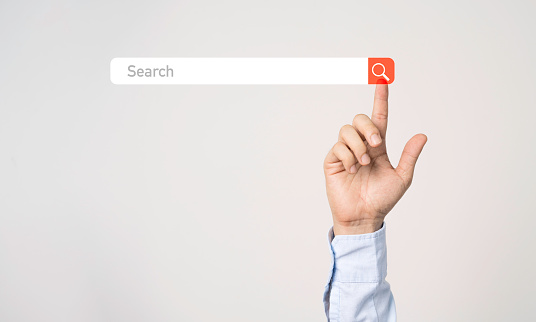 Businessman hand touching to search engine browser icon to input and finding new business trends.