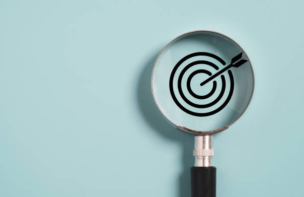 target board innen aus lupeglas für fokus geschäftsziel auf blauem hintergrund und kopierraum. - marketing target bulls eye arrow stock-fotos und bilder