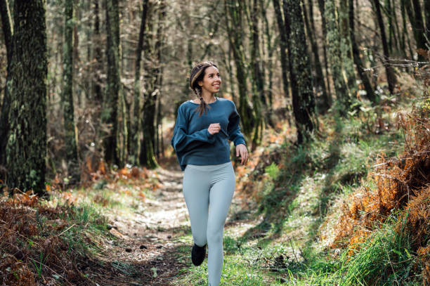 istock Sporty woman running in forest 1316414365