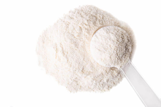 Heap of white protein powder with measuring spoon Heap of white protein powder with measuring spoon isolated on white background. handful stock pictures, royalty-free photos & images