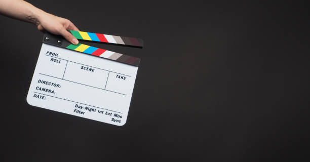 istock Hand is holding clapperboard or movie clapper board or slate on black background 1316416603