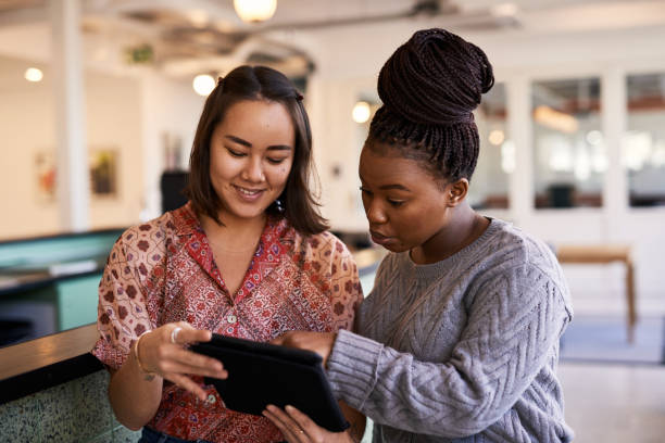 istock Shot of two young friends looking at a digital tablet 1316419171