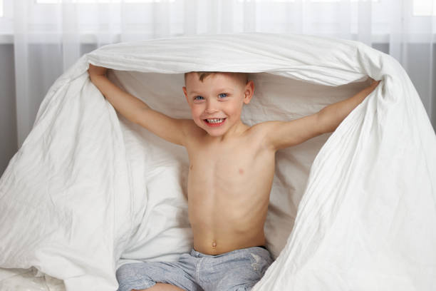 istock The cute boy smiling covered his head with a white blanket 1316419578