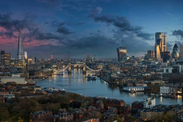 the urban skyline of london along the thames river with tower bridge  during dawn - tower bridge fotos imagens e fotografias de stock
