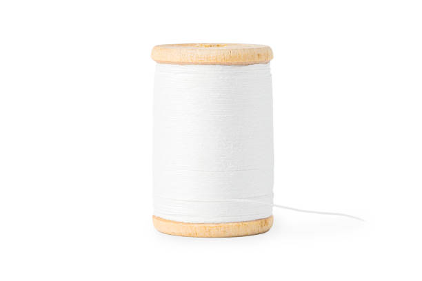 wooden spool with white thread close up on white background.