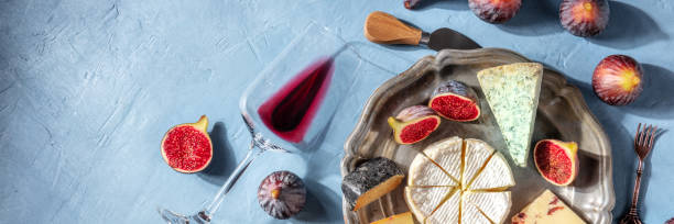 istock Wine and cheese panorama with red wine in a glass and a cheese platter 1316424016