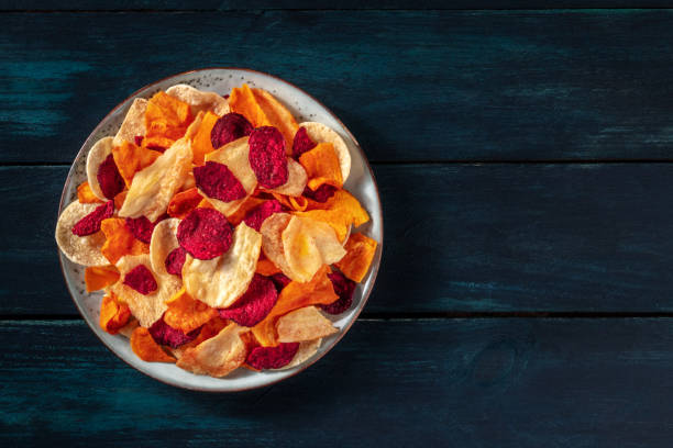 istock Vegetable chips, shot from the top on a dark wooden table with copy space 1316424351