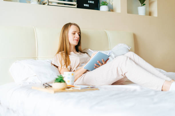 istock Blonde woman in bed with book 1316425256