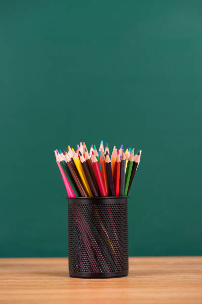istock metal cup with pencil on desk on green chalkboard background 1316425484