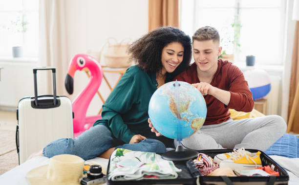 istock Young couple with map packing for holiday at home. 1316425691