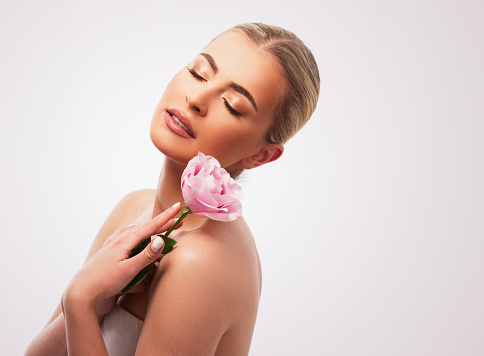 Beautiful woman holding a beautiful pink rose flower